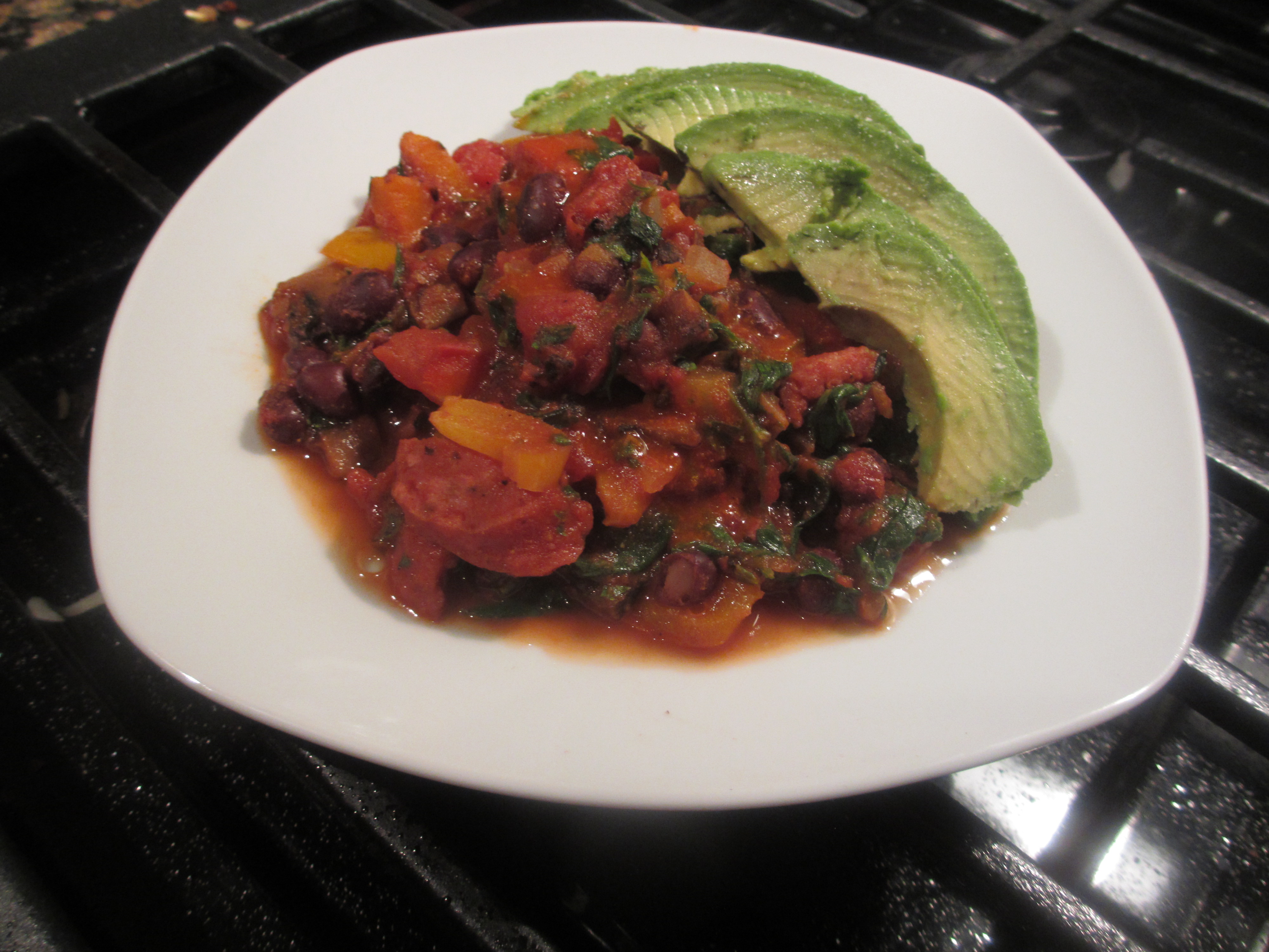 Cooked beans, peppers, onions, sausage, and diced tomatoes with avocado