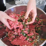 Mixing ground meat, chopped parsley, onions, and tomatoes
