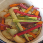 Carrots and onions in a pot with swiss chard stalks