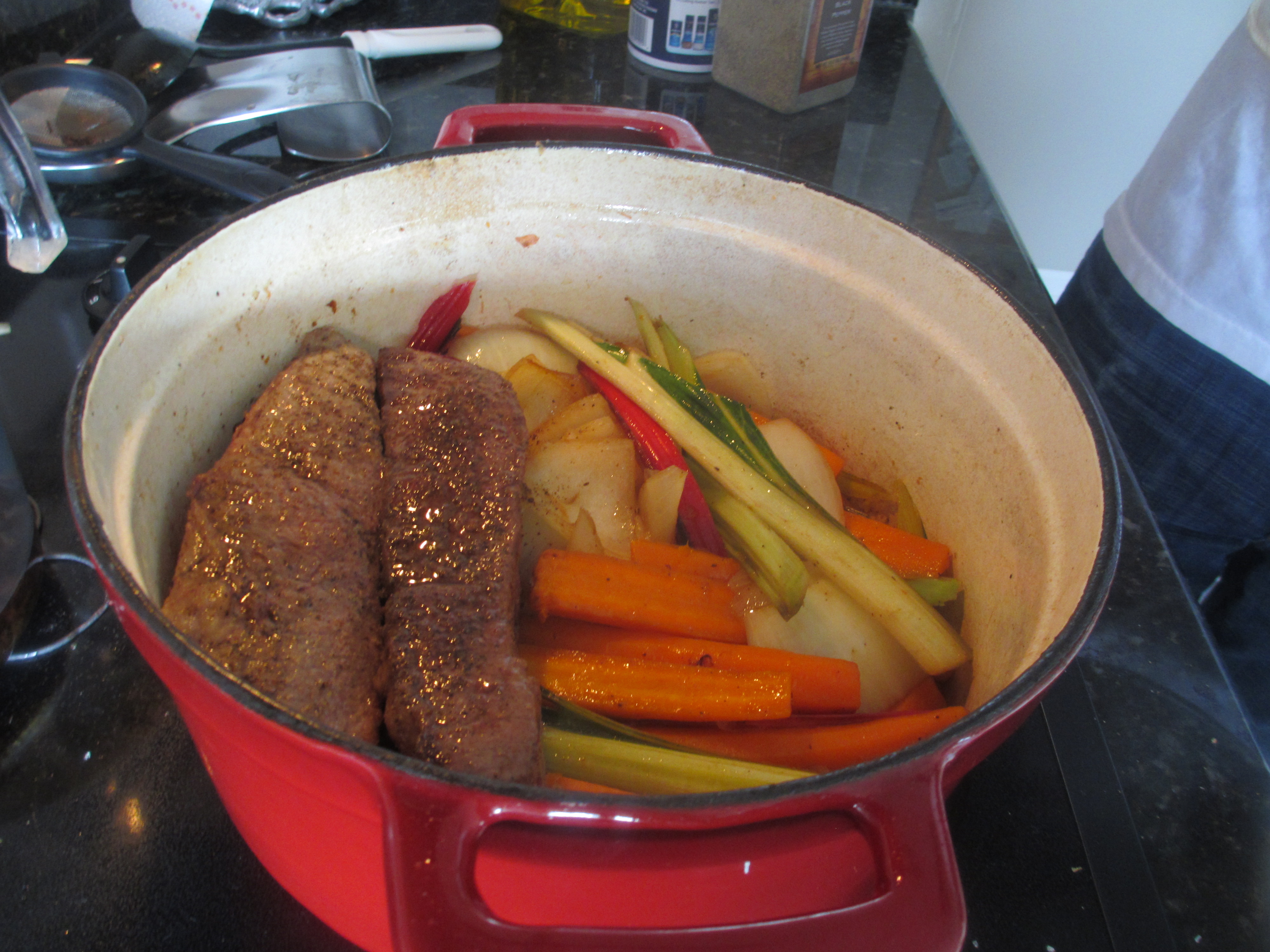 Short ribs being added to the cast iron pot