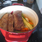 Short ribs being added to the cast iron pot
