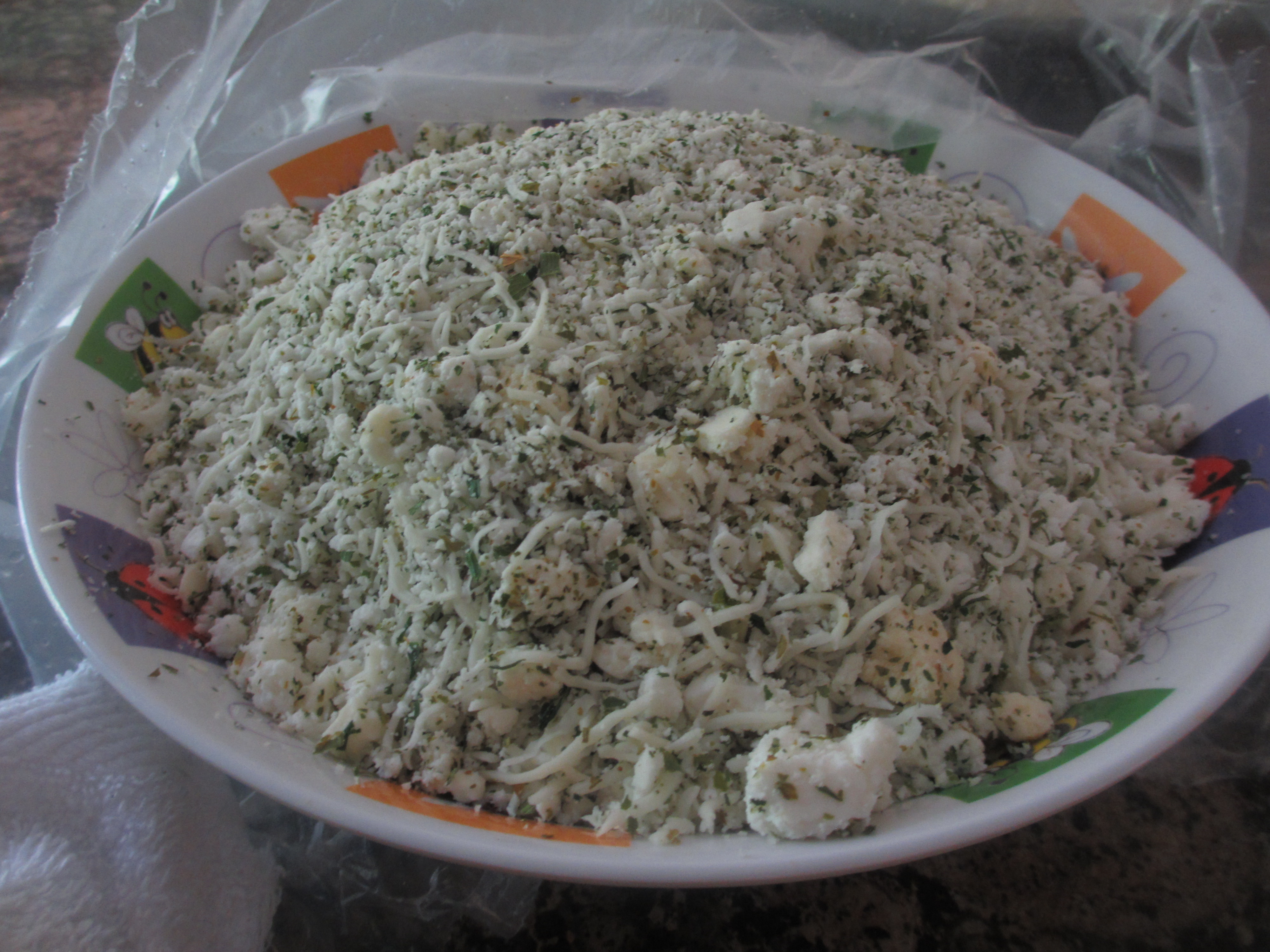 Cheeses mixed with parsley in a bowl