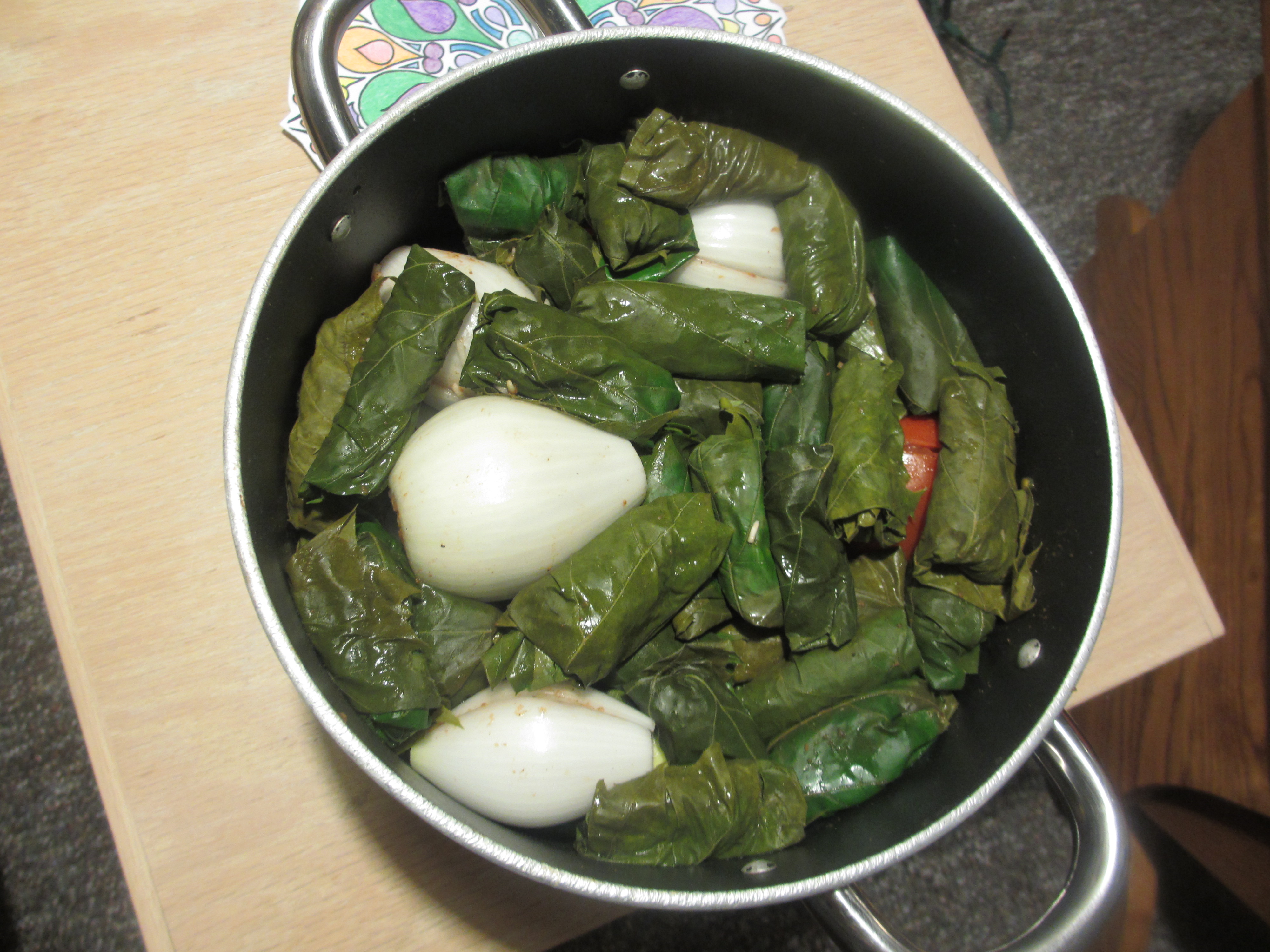 Pot of stuffed grape leaves, onions, zucchini and tomatoes