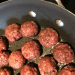 Spiced meatballs cooking in a sauce pan