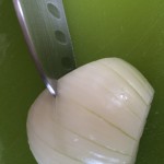 Onion being sliced with a santoku knife