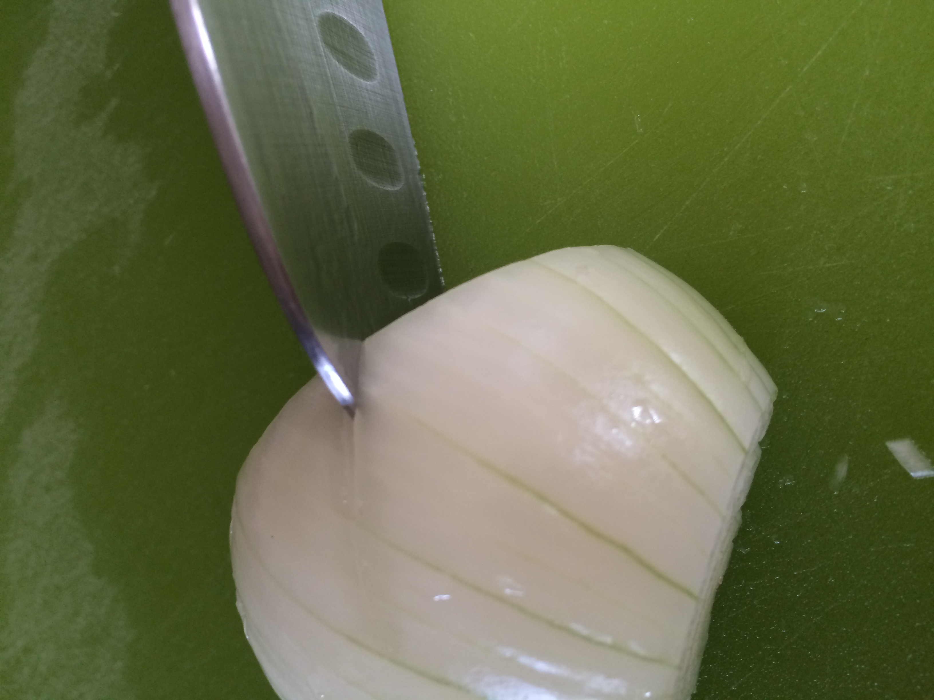 Onion being sliced with a santoku knife