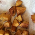 Fried potato cubes on a paper towel