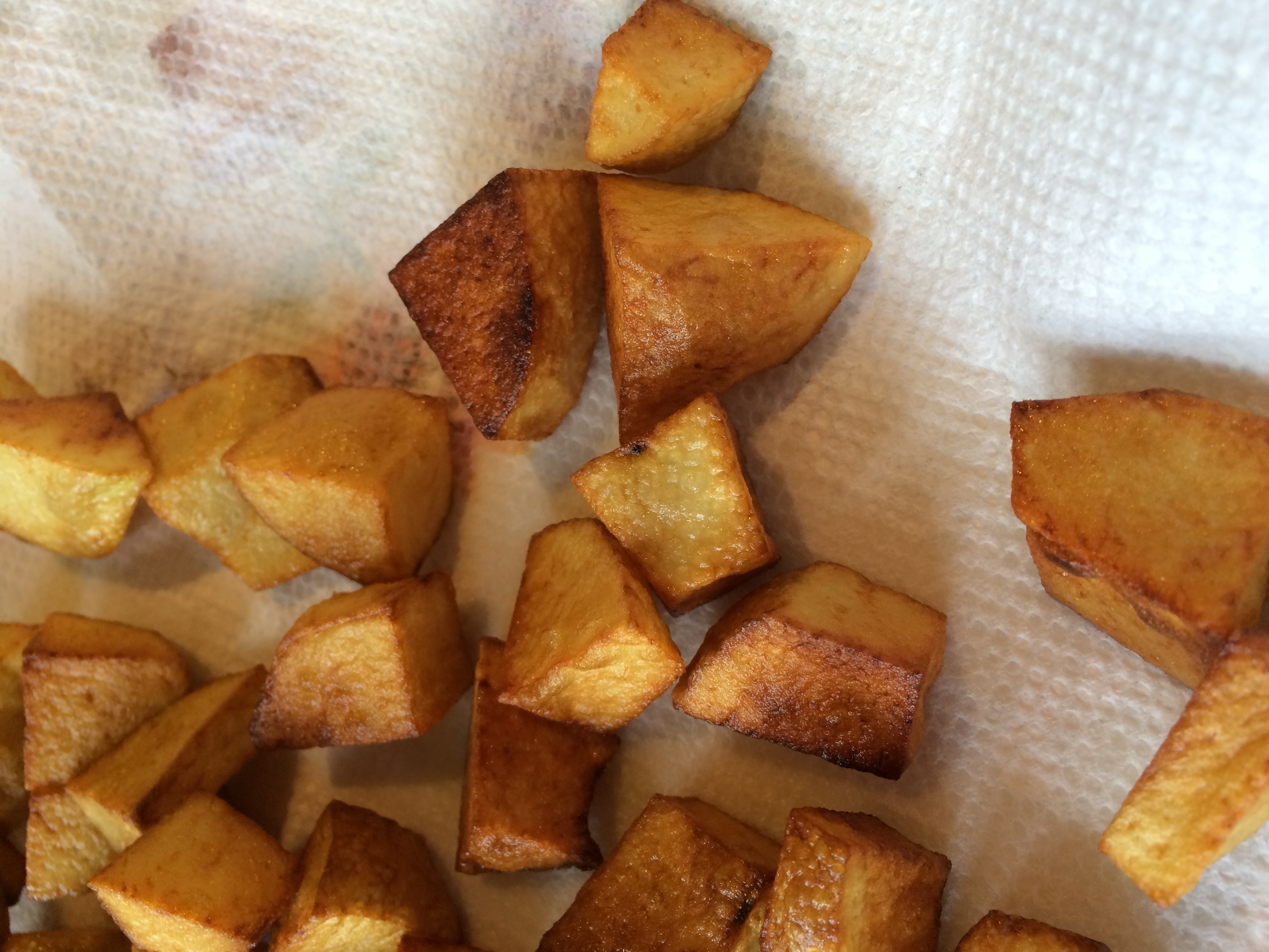 Fried potato cubes on a paper towel