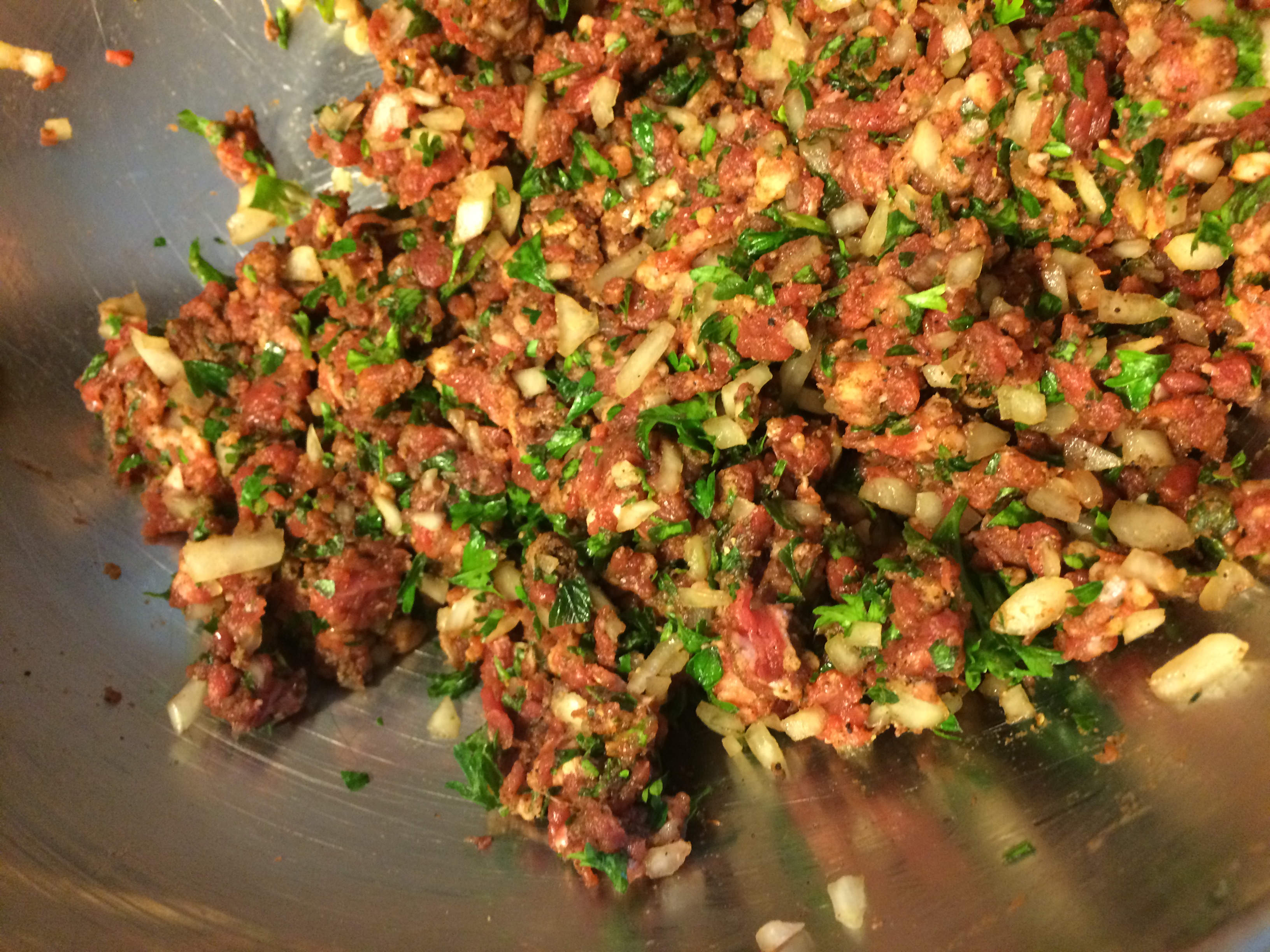 Coarse ground beef, mixed with parsley, spices, and onions