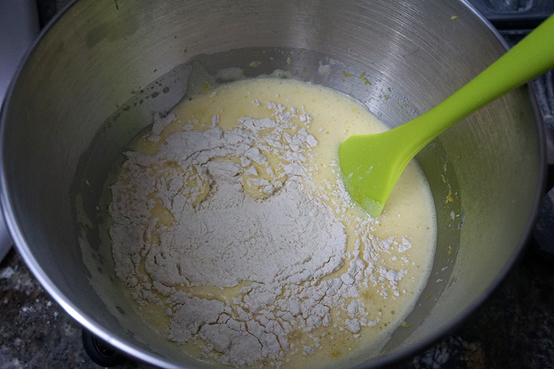 Adding flour to the egg and lemon zest mixture