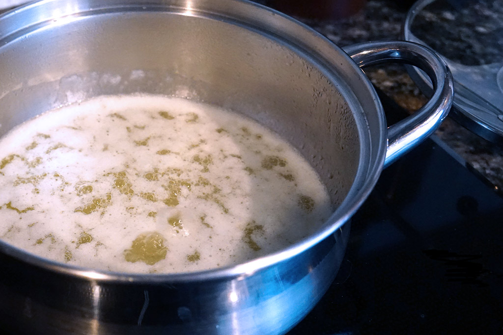 Butter boiling on the stove in a small stainless steel pot