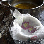 Lining strainer with butter to strain clarified butter