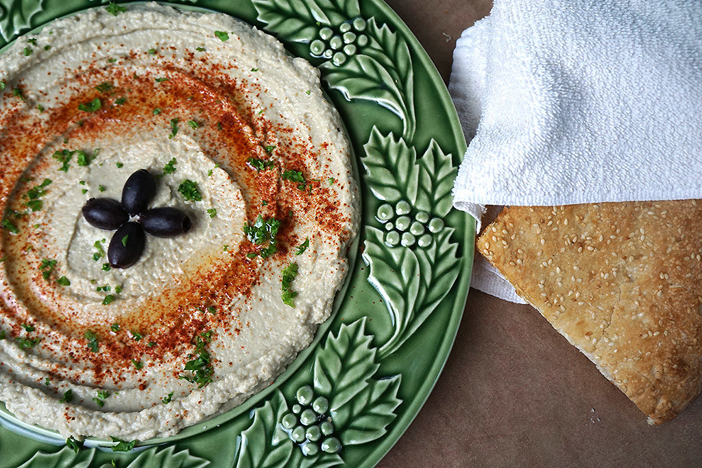 Baba Ghanouj with a piece of bread wrapped in a towel 