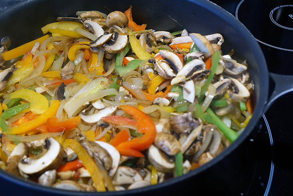 Peppers, onions, and mushrooms in a pan