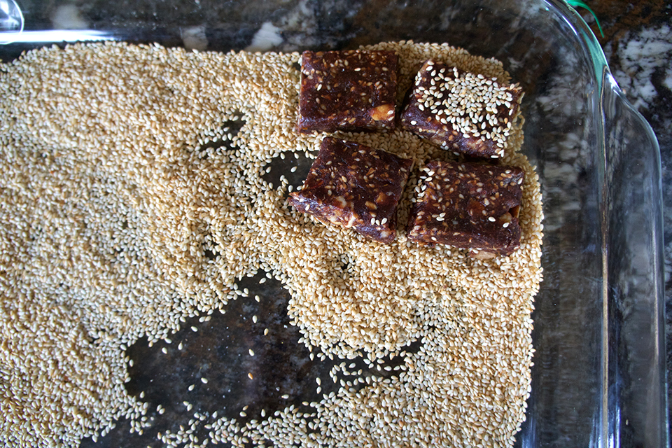 Dipping dates in sesame seeds