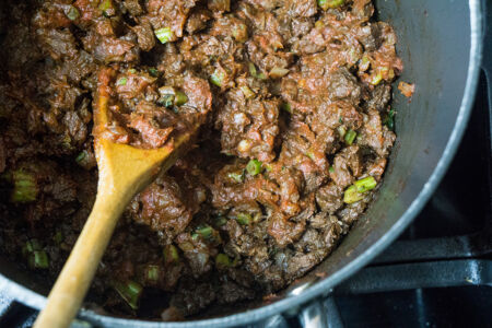 Browning tomato paste with meat, onions, and kale stems Browning tomato paste with meat, onions, and kale stems